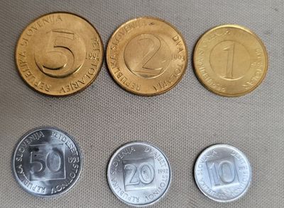 four different coins sitting on top of a table next to each other