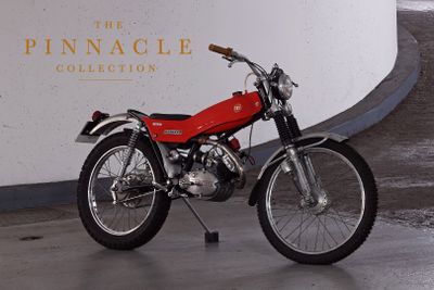 a red motorcycle parked in front of the pinnacle collection sign