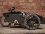 a black motorcycle with a sidecar parked in front of a brick wall