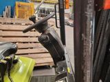a forklift in a warehouse with pallets in the background