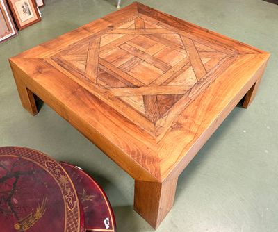 une table en bois ornée d'un motif, dans une pièce