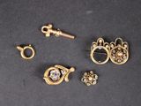 trois paires de boucles d'oreilles et une clé posées sur une surface noire