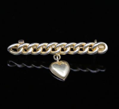 a close up of a gold and silver bracelet with a heart charm