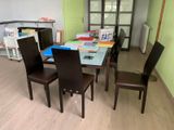 a table and chairs in a room with books on the table