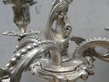 un lustre en argent sur lequel sont posées deux bougies