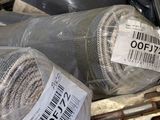 two rolls of fabric wrapped in plastic on a metal shelf
