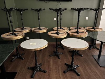 plusieurs tables et tabourets dans une pièce où une télévision est accrochée au mur