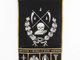a black and gold banner with a skull and cross on it