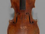 a close up of a violin on a gray surface