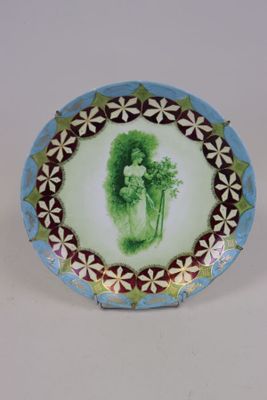 une assiette sur laquelle est représentée une femme tenant une fleur