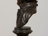 statue of a bust of a man on a pedestal on a table