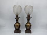 une paire de vases noirs et dorés ornés de fleurs blanches