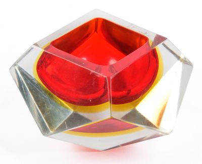 a red and yellow object in a clear glass bowl