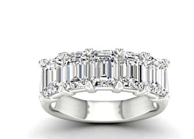 une bague en or blanc sertie de cinq émeraudes sur les côtés
