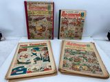 three old comic books sitting on top of a white table