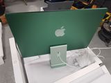 a green apple laptop computer sitting on a white table