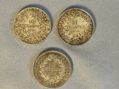 trois pièces d'or posées les unes à côté des autres sur une table