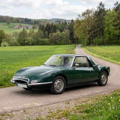 an image of a green car driving down a dirt road