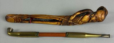 a wooden pipe and a brass pipe holder next to each other