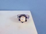 un gros plan d'une bague posée sur une table, sur fond bleu
