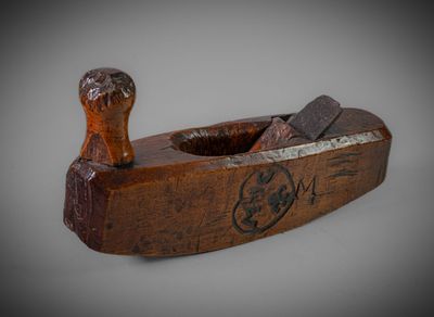 an old wooden plane with a wooden handle on a gray surface