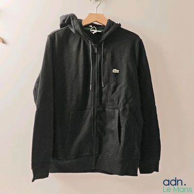 une veste noire accrochée au mur à côté d'un cintre