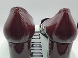 pair of red high heeled shoes sitting on top of a white box