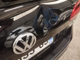 a close up of a volkswagen logo on a black car