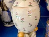 un grand vase blanc orné d'un oiseau, posé sur un comptoir bleu