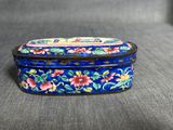 une petite boîte bleue ornée d'un motif floral