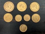 six types différents de pièces d'or sur une surface noire