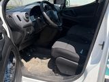 the interior of a white truck with the door open and the driver ' s seat down