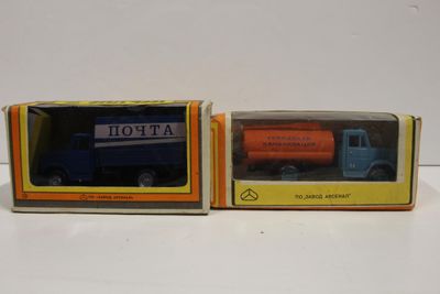 deux jouets emballés représentant un camion bleu et orange et un camion bleu et orange