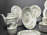 a lot of plates and cups that are sitting on a table