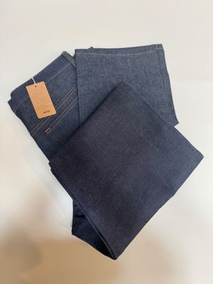 three pairs of blue jeans folded on top of each other