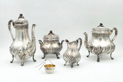 a silver tea set on a white background with a bowl