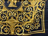 a gold and black scarf with a picture of a man on a horse