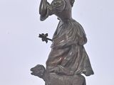 a statue of a woman with a pot on her head and a dog