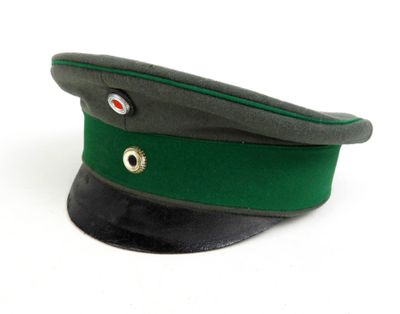 casquette militaire verte et noire sur fond blanc, avec un œil rouge