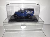 a blue truck in a clear display case on a table