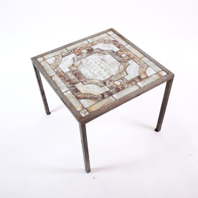 an image of a small table with a mosaic top and metal legs