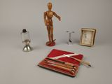 a wooden mannequin and other objects on a table