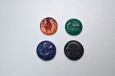 quatre cachets de cire de couleurs différentes sur une surface blanche