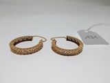 a pair of gold hoop earrings on a white surface