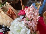 un panier de fleurs posé sur une table, à côté de flacons d'huiles essentielles