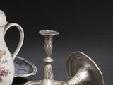 deux bougeoirs en argent et un vase posés sur une table