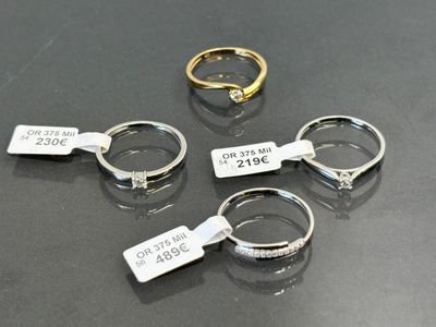 three rings with tags on them are sitting on a table