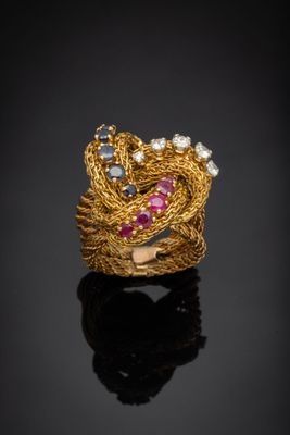 a close up of a gold ring with pink and blue stones