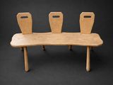 un banc en bois sur lequel sont posées trois chaises