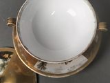 a cup and saucer sitting on a table next to a plate